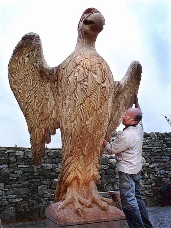 Wooden carved eagle with sculptor