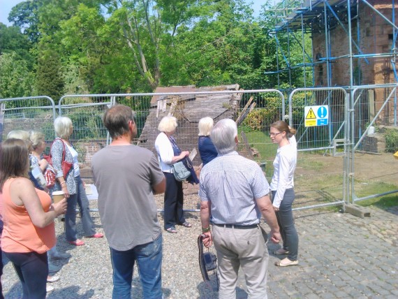 tour group at the mill group of people looking at scaffolded building